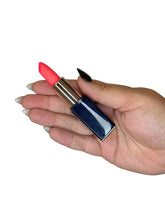 Hand holding a red lipstick discrete vibrator with a blue case on a white background