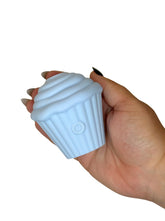 Hand holding a light blue cupcake-shaped object against a white background