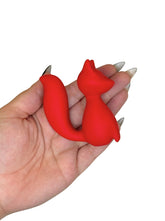 Red cat-shaped object held in a hand with a white background