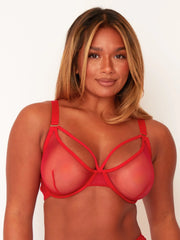 Woman wearing a red strappy bra against a white background
