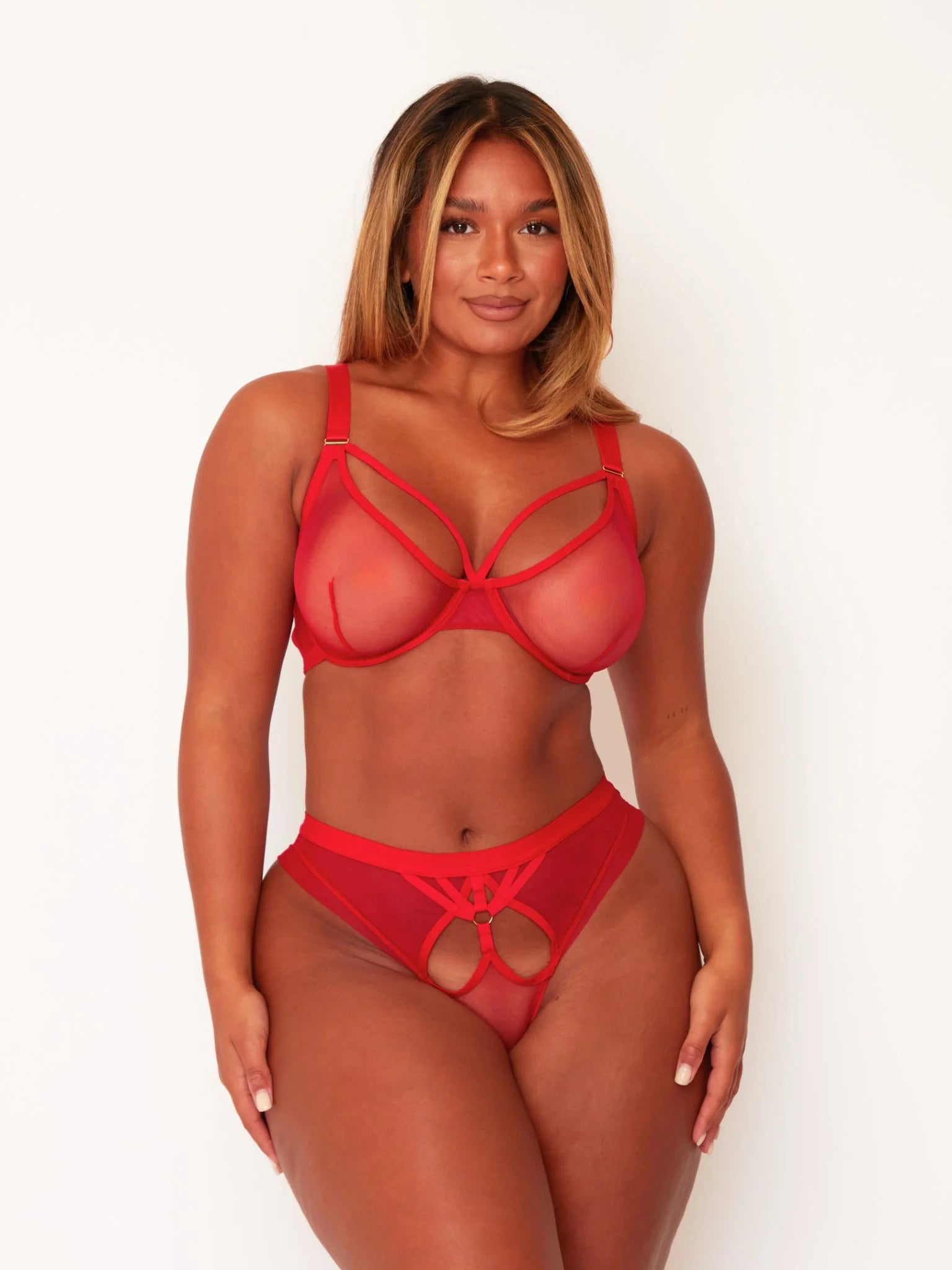 Woman wearing a red lingerie set on a white background