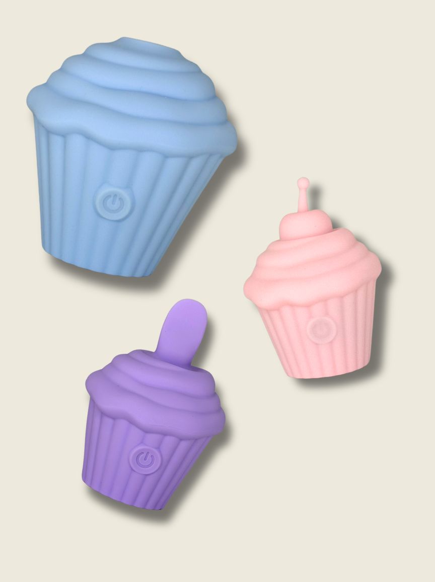 Three silicone cupcake-shaped discrete sex toys in blue, purple, and pink on a beige background.