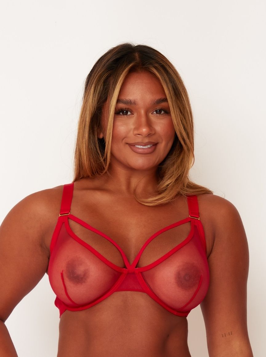Woman wearing a red strappy top against a white background